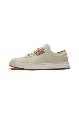 Beige lage sneaker met bruine accenten, rubberen zool en Timberland boomlogo aan de hielzijde.