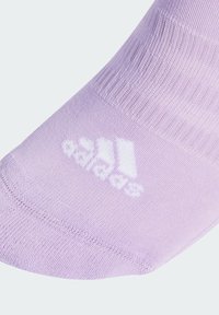 Calcetín deportivo morado con textura acanalada y puntera reforzada. Presenta un logo blanco de Adidas cerca del tobillo.