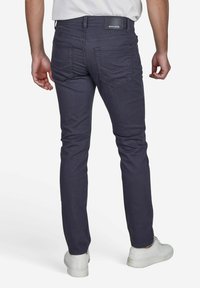 Dunkelblaue Slim-Fit-Jeans mit glatter Textur, fünf Taschen und einem Marken-Lederpatch am hinteren Bund.