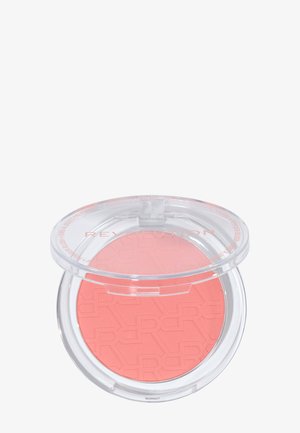 Compact round coral blush with embossed letters, housed in a clear plastic case with a transparent hinged lid.