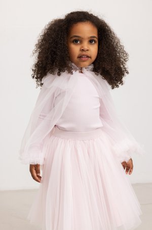 Pale pink dress featuring a ribbed bodice, tulle skirt, and sheer cape sleeves with ruffled edges. Simple, elegant design with a soft texture.