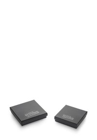 Dos cajas cuadradas y negras con una textura suave y un acabado mate, que presentan la inscripción "¡VERDADEROS REBELDES!" en una fuente contrastante.