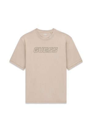 Beež lühikeste varrukatega T-särk ümar kaelusega ja "GUESS" logo suurte, paksude tähtedega rinnal.