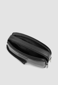 Portafoglio in pelle nera con superficie testurizzata, doppio scomparto con cerniera e cinturino da polso. Interno con multiple fessure per carte.