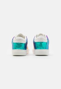 Wielokolorowe sneakersy z błyszczącą, turkusową i fioletową skórzaną cholewką, białą gumową podeszwą oraz złotym logo na pięcie. Zawierają teksturowane akcenty.