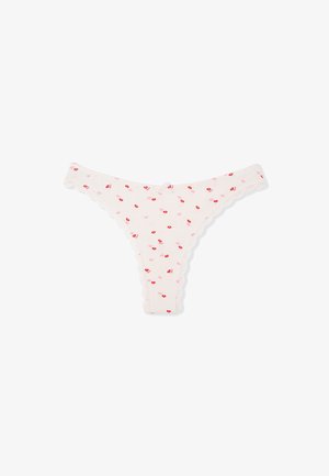 White thong underwear with a scalloped lace trim, adorned with a pattern of small red lips on a soft fabric background.