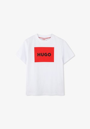 T-shirt en coton blanc avec un graphique rectangulaire rouge portant "HUGO" en lettres noires en gras au centre. Col rond et manches courtes.
