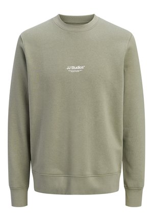 Light olive green crewneck sweatshirt with long sleeves and small white "JJ Studios" logo centered on chest.