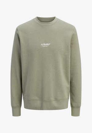 Light olive green crewneck sweatshirt with long sleeves and small white "JJ Studios" logo centered on chest.