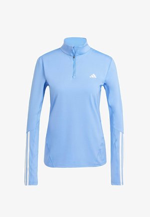 Lys blå langærmet top med kvart-zip krave, prydet med hvidt Adidas-logo og tre hvide striber langs ærmerne. Glat stoftekstur.