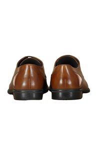 Bruine leren schoenen met een gladde textuur, ronde neus, lage hak en een minimalistisch ontwerp. Voorzien van een zwarte rubberen zool en subtiele stiksels.