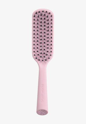 Brosse à cheveux rose avec tête rectangulaire plate et poils noirs, certains emmêlés avec des mèches de cheveux.