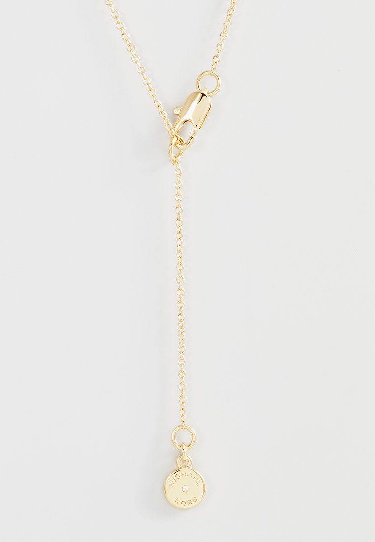 Collana in oro con chiusura a moschettone e piccolo pendente rotondo inciso con "Michael Kors" e una pietra centrale trasparente.