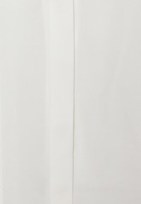 Tissu blanc avec une texture lisse, affichant un design simple et sans couture. Présente un éclat léger, mettant en valeur sa légèreté et son minimalisme.