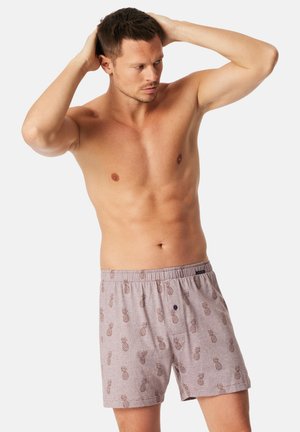 Helle graue Herrenboxershorts mit elastischem Bund, versehen mit einem wiederholten Ananas-Muster in Dunkelbraun. Weicher Stoff mit entspannter Passform.