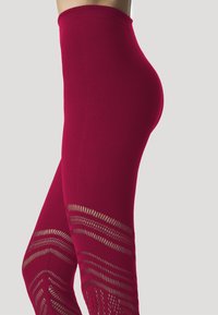 Leggings rossi a vita alta con una texture liscia e un motivo geometrico ritagliato nella parte inferiore della gamba, che offrono un design traspirante.