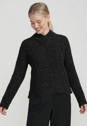 Black, fuzzy knit sweater with long sleeves and a high neckline. The fabric has a textured appearance and a loose fit. Features a straight hem.