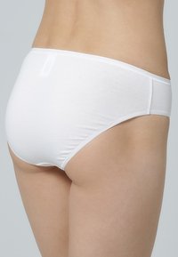Witte katoenen ondergoed met een gladde textuur, lage taille en minimale rugbedekking. Heeft een rechte tailleband en geen zichtbaar stiksels.