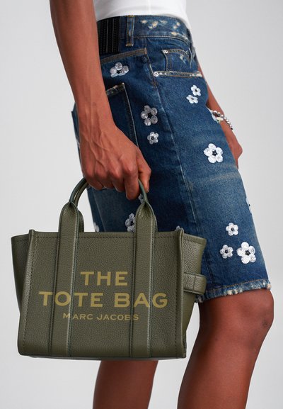 Olijfgroene leren tote bag met geperst ontwerp "THE TOTE BAG MARC JACOBS." Korte handvatten, gestructureerd ontwerp en een textuur oppervlak.