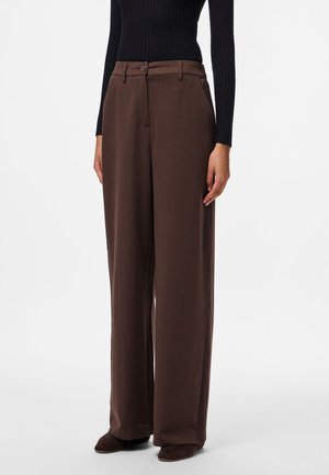 Pantalons marron à jambes larges avec une texture lisse, dotés d'une fermeture à bouton, de passants de ceinture et de poches latérales, associés à un haut noir ajusté.