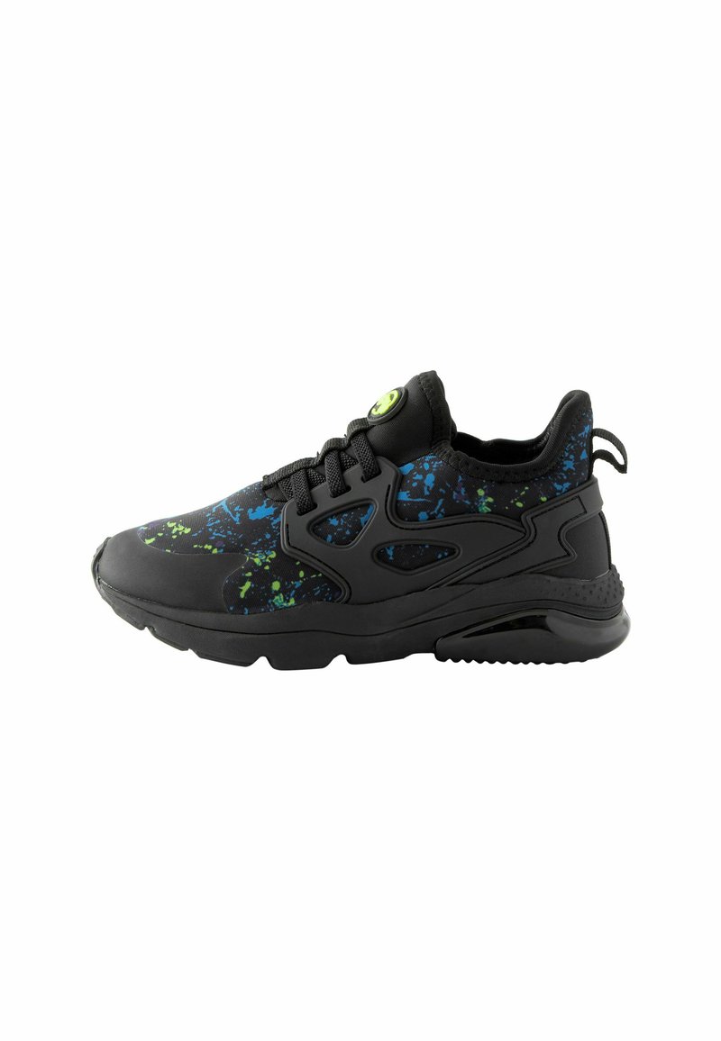 Black athletic shoe with a splash pattern in blue and green accents, featuring a textured outsole and a prominent green eyelet on laces.