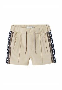 Pantaloni beige con una texture morbida, caratterizzati da pannelli laterali blu navy con un motivo a quadri e la scritta "SPEED RACE". Include tasche anteriori e un cordoncino.
