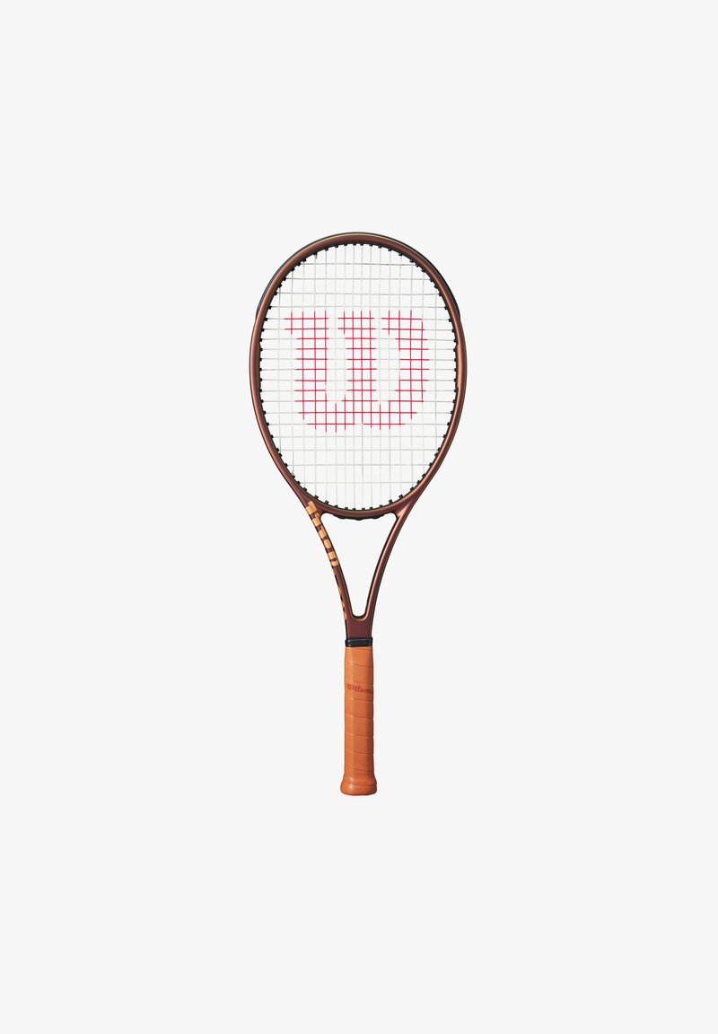 Raqueta de tenis marrón con un empuñadura texturizada naranja, marco ovalado, cuerdas blancas y un destacado logo rojo "W" en la parte superior.