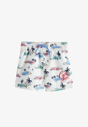 Pantalones cortos blancos con cordón azul, decorados con coches vintage coloridos, palmeras, banderas a cuadros y el texto "Café Motel" en rojo.