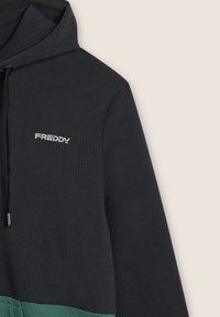 Felicità con cappuccio caratterizzata da una sezione superiore grigio scuro e una fascia inferiore verde. Include un logo frontale "FREDDY" in argento. Texture liscia.