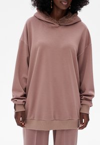 Oversized, licht mauve hoodie met een zachte, getextureerde voering in de capuchon; geribde manchetten en zoom; zachte stof, relaxte pasvorm.