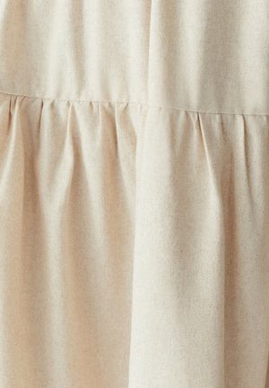 Light beige fabric with a textured finish, featuring gathered pleats creating volume. The material appears soft and slightly woven.