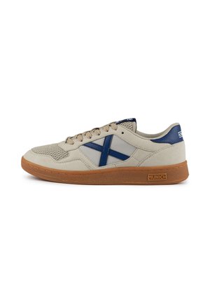 Zapatillas beige con un upper texturizado, acentos en azul marino y suela de goma. Presentan un panel de malla y un logotipo en el talón.