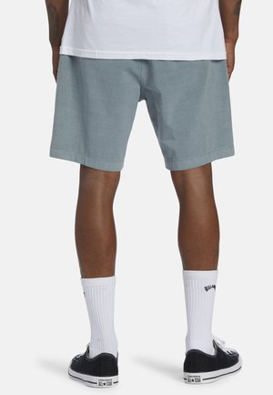 Ljusblå shorts i bomull med en avslappnad passform, med en nederdel som faller strax ovanför knäna. Matchas med vita strumpor och svarta sneakers.