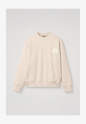 Sweat-shirt beige à manches longues avec col ras du cou, petit logo blanc et texte sur le côté gauche de la poitrine, poignets et ourlet côtelés.