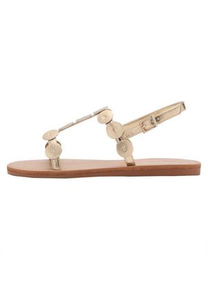 Gouden metallic platte sandaal met ronde accenten, verstelbare enkelband en een zachte bruine zool. Eenvoudig ontwerp met een minimalistische uitstraling.