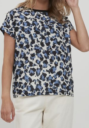 Top de manga corta con un estampado de leopardo azul y negro sobre un fondo claro, con un cuello redondo y un corte relajado. Textura de tela suave.