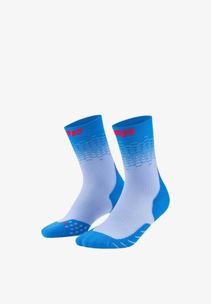 Blue and white athletic crew socks with red logo, featuring a gradient pixel pattern and textured grip dots on the soles.