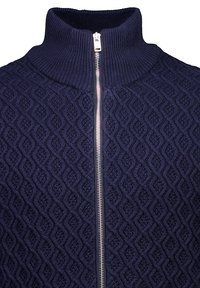 Mörkblå zip-up tröja med hög krage. Har en strukturerad diamantsk struktur och silverfärgad dragkedja. Tillverkad av en stickad material.