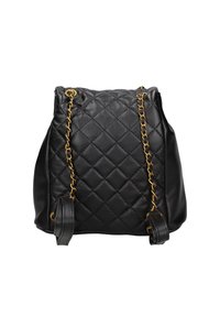 Zaino in pelle trapuntata nera con dettagli in catena dorata, caratterizzato da una forma arrotondata e chiusura a cordoncino. Texture liscia con cuciture visibili.