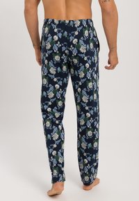Floral pyjamabroek met een marineblauwe achtergrond, een levendig groen en blauw bloemenpatroon, een elastische tailleband en een recht gesneden pijp.
