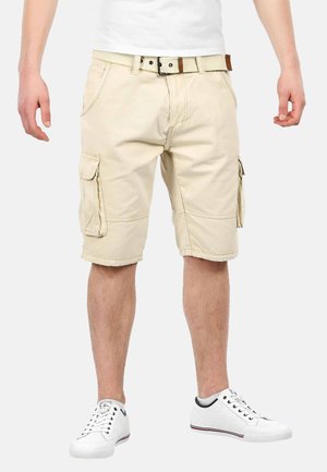 Beige Cargo-Shorts mit seitlichen Taschen, einem umgeschlagenen Saum und einem Standardbund mit einem Gürtel. Tragen Sie dazu weiße Sneakers.