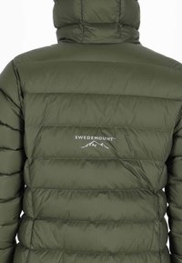 Olivgrüne Steppjacke mit gestepptem Design, einem hohen Kragen und dem "SWEDEMOUNT"-Logo in Weiß auf der Rückseite.