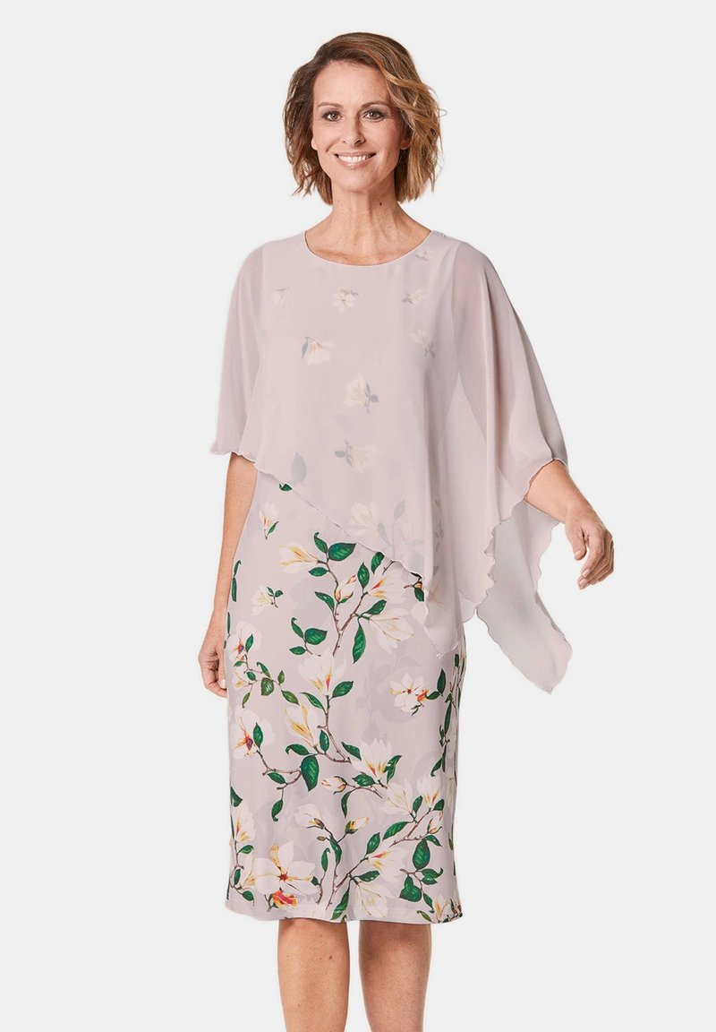 Leichtes Blumenkleid mit einem fließenden, transparenten Überzug und kurzen Ärmeln. Die Farben umfassen zartes Rosa, Grün und weiße Blumenmuster.