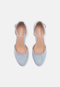 Světle modré semišové boty na kotníkovém pásku s designem špičaté špičky a malou sponou, se silnou vnitřní podšívkou a hladkou texturou.