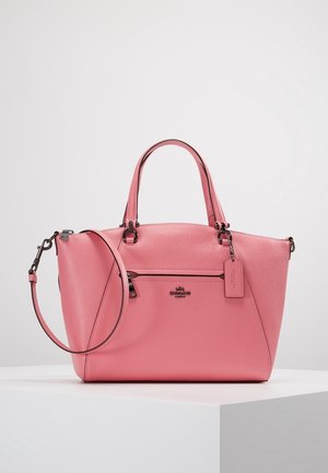 Rosa læderhåndtaske med dobbelte håndtag, aftagelig skulderrem, lynlåslomme foran og Coach-logo på hvid overflade.