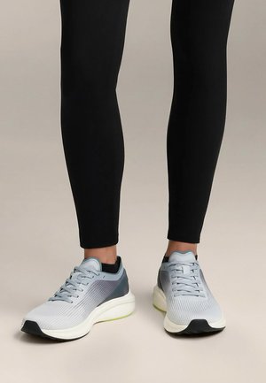 Scarpe sportive leggere realizzate in mesh grigio chiaro con accenti grigio scuro, dotate di una suola spessa bianca e tacco nero.