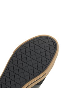 Sole della scarpa realizzata in materiale gommoso nero con un motivo a diamante. I bordi sono beige, offrendo contrasto e aderenza.