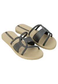 Sandali piatti neri luccicanti con design a tracolla intrecciato; suola beige con superficie testurizzata; cinturini regolabili per il massimo comfort.
