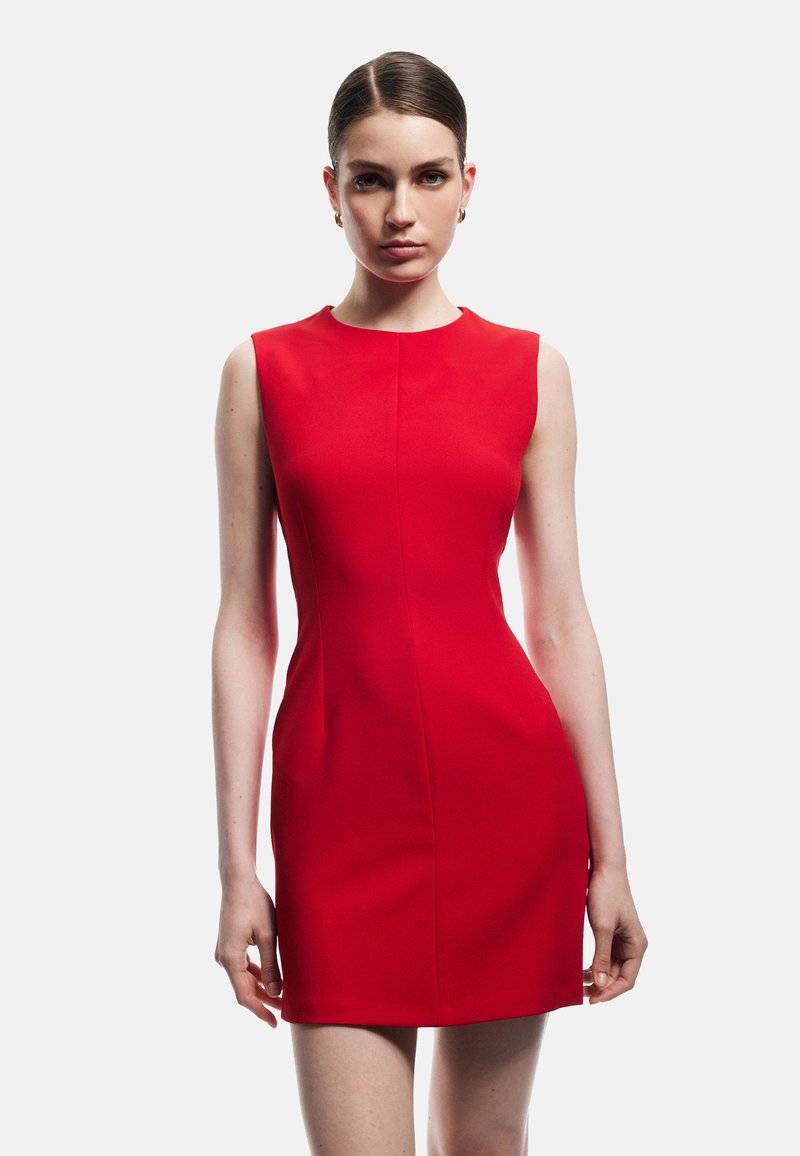Robe sans manches rouge avec une silhouette ajustée, un col rond et des coutures minimales. Le tissu semble lisse et légèrement extensible.