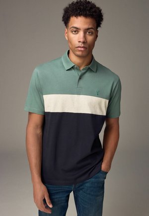 Polo-shirt med korte ærmer i salviegrøn top, beige stribe og marineblå bund. Lavet af glat bomuld med krave og tre knapper.